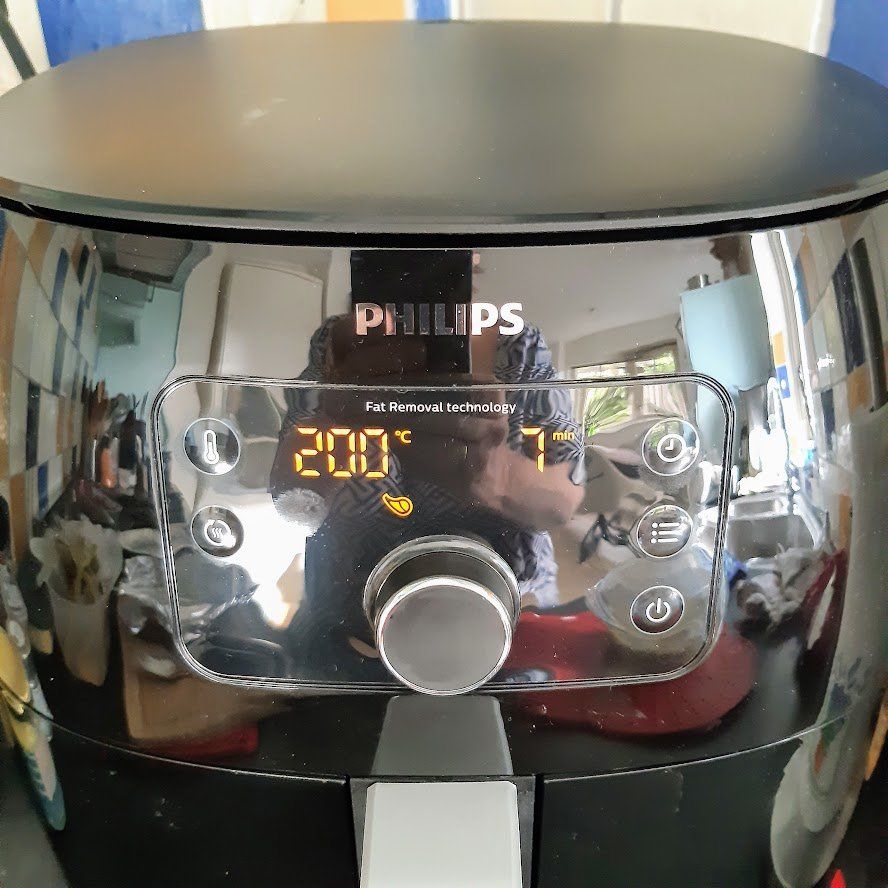 Zwarte Philips airfryer met digitaal display waarop 200°C en 7 minuten worden weergegeven.
