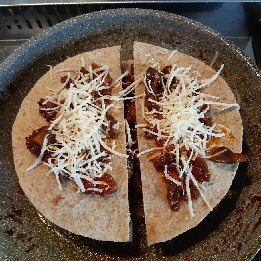 Quesadilla in een pan: tortillahelften gevuld met kaas en geraspte kaas.
