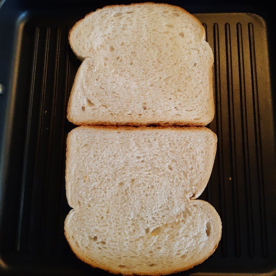 Twee sneetjes brood in een grillpan, klaar om geroosterd te worden.