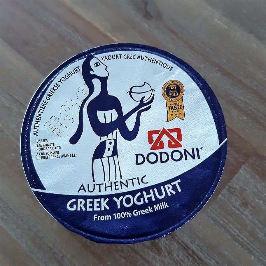Dodoni Authentic Greek Yogurt verpakking. Blauw-wit etiket met afbeelding van een vrouw en de tekst 