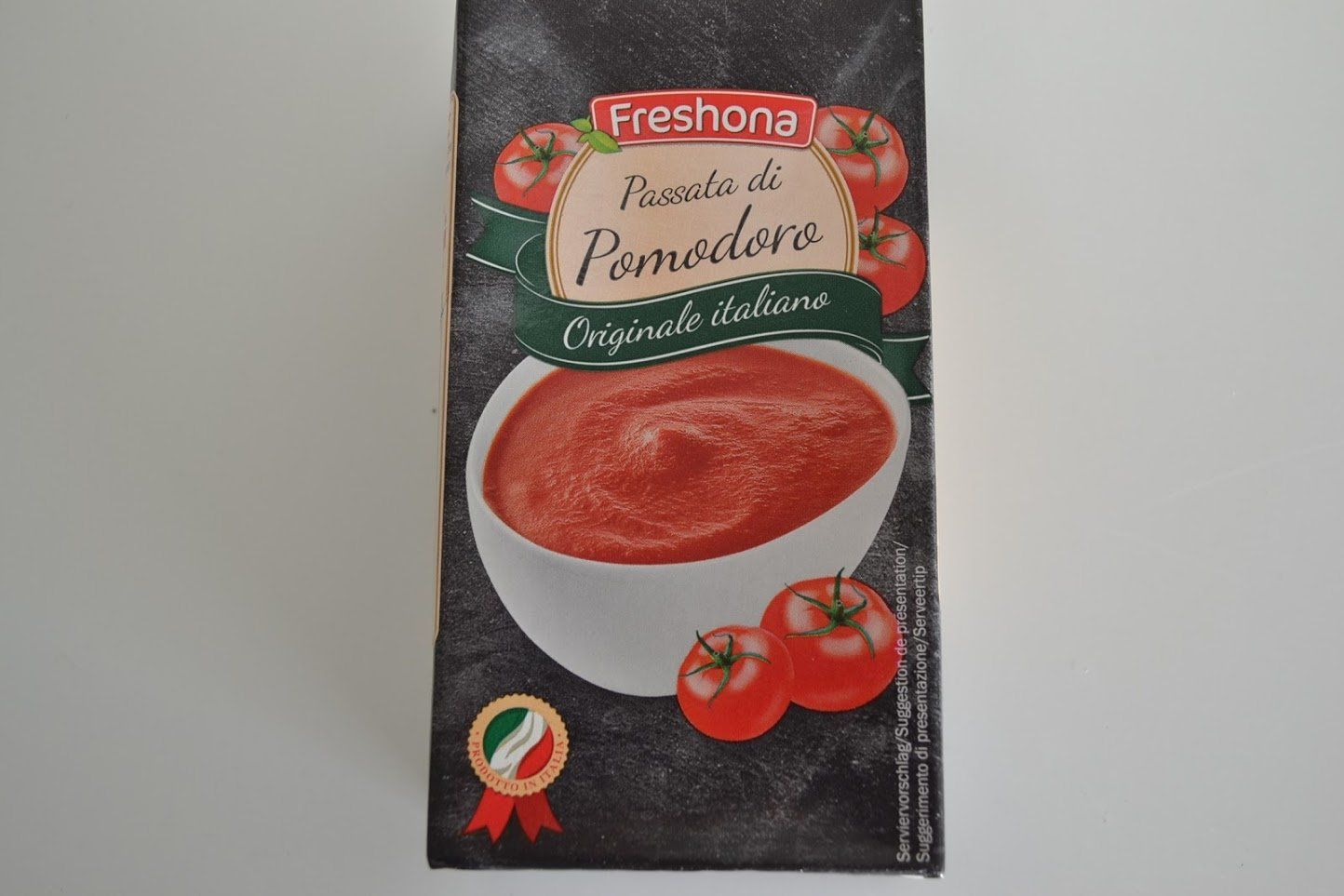 Doos Freshona tomatenpuree met afbeelding van tomaten en saus.