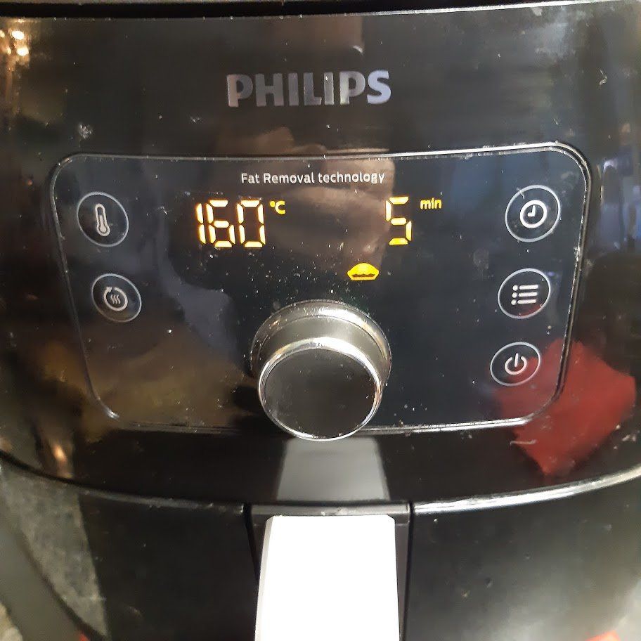 Zwart Philips airfryer bedieningspaneel ingesteld op 160 graden Celsius gedurende 5 minuten.