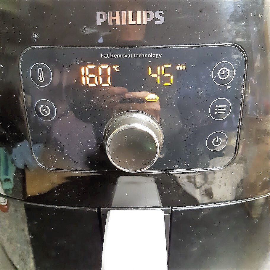Zwart Philips bedieningspaneel voor de airfryer met weergave van 160 °C en 45 minuten, met een draaiknop en diverse knoppen.