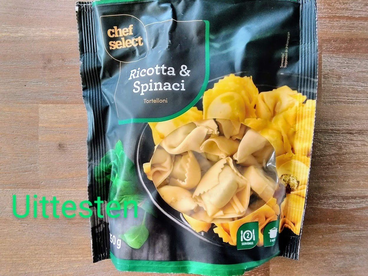 Chef Select Ricotta & Spinaci tortellini verpakking. Pasta in een zwart-groene zak op een houten tafel.