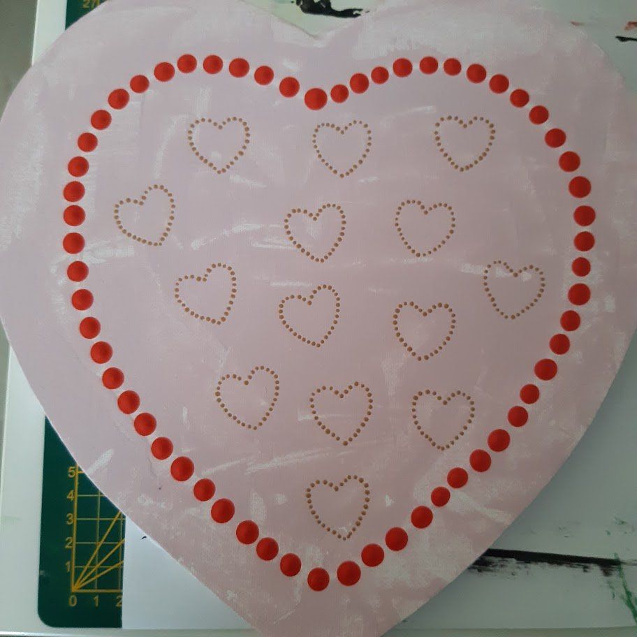 Roze hart met een rode stippenrand, met kleinere hartjes met stippen erin.