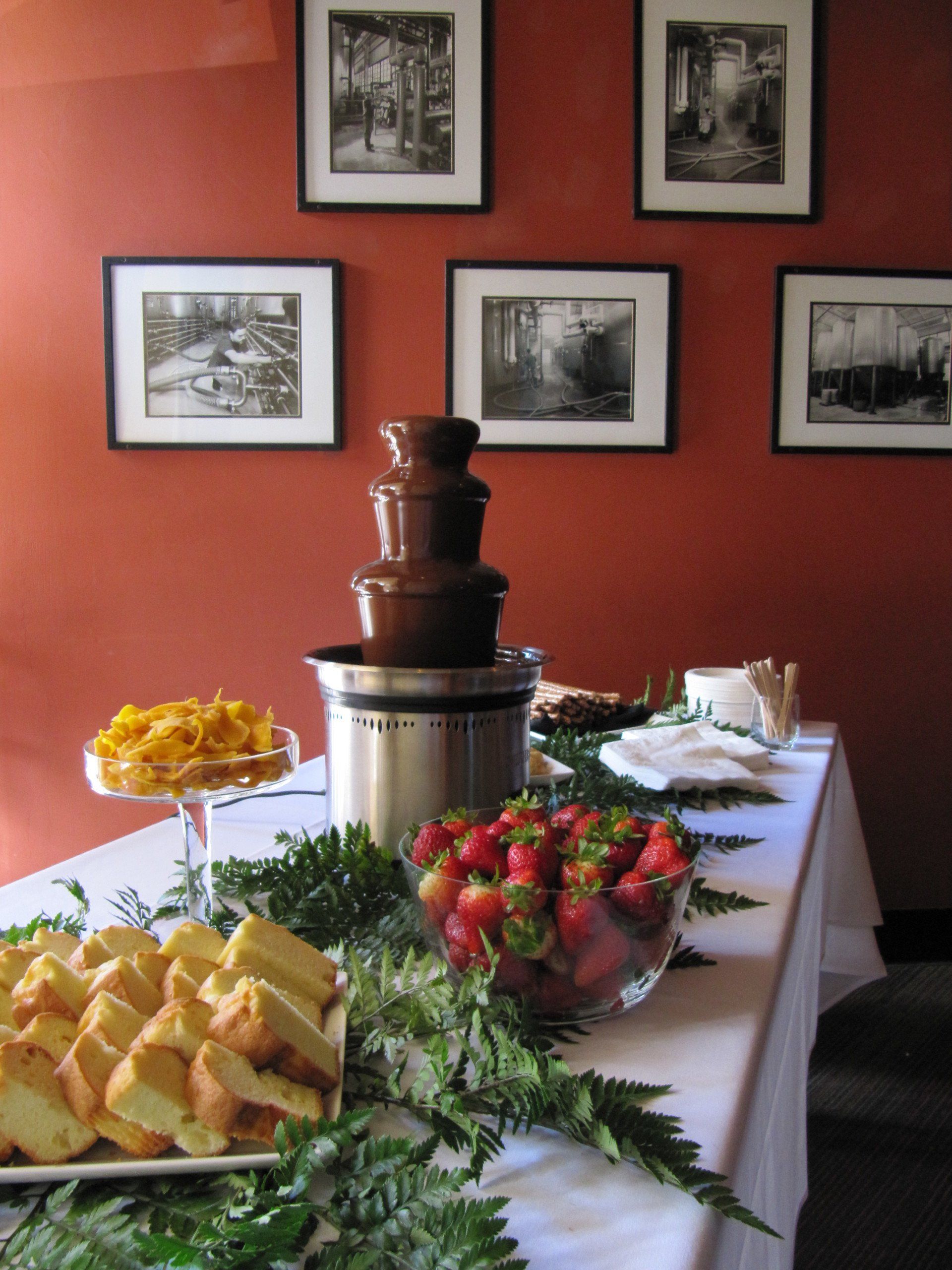 a table with a chocolate fountain and strawberries on it