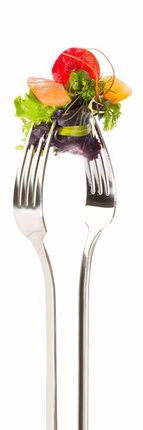 Eine Gabel mit einem Salat darauf auf einem weißen Hintergrund.