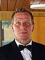 A man in a tuxedo and bow tie is standing in a room.