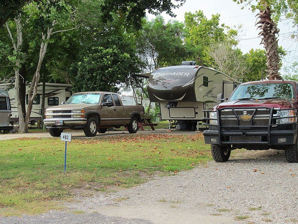 A truck and a rv are parked in a campground.