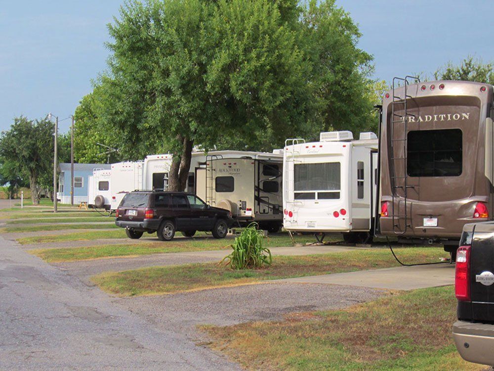 A truck is parked next to a rv that says tradition