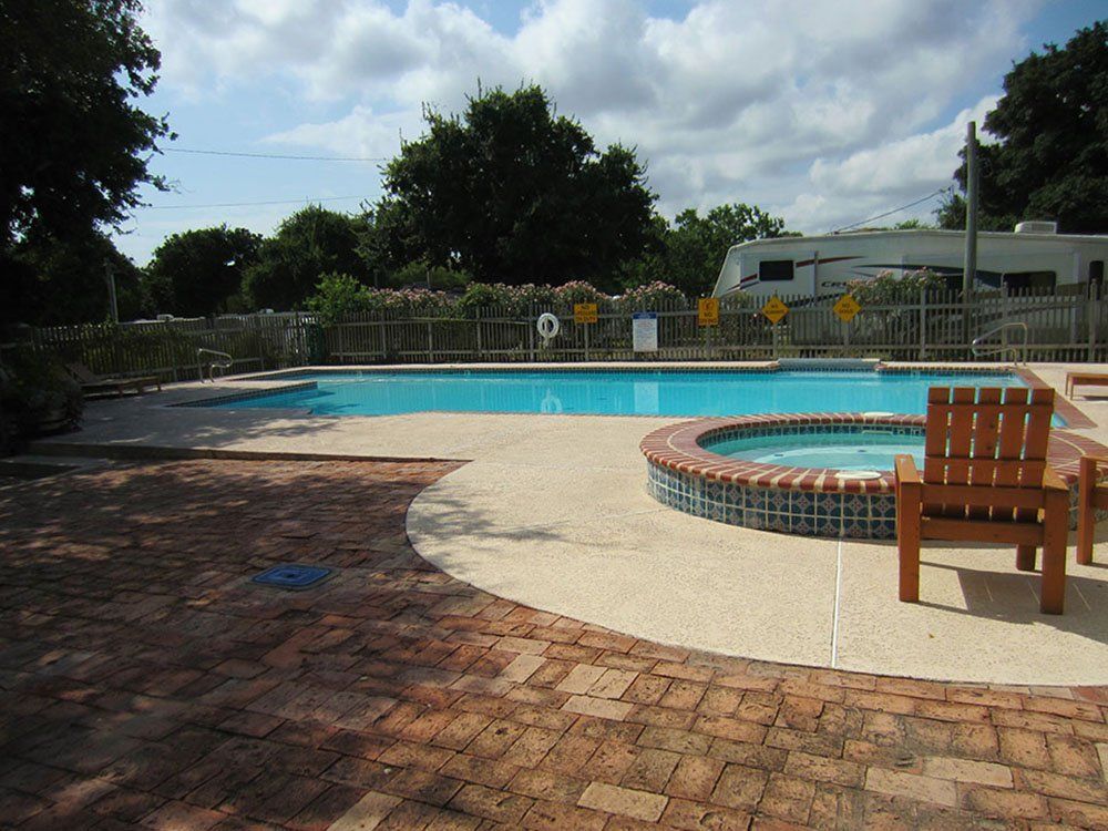 A large swimming pool with a hot tub in the middle