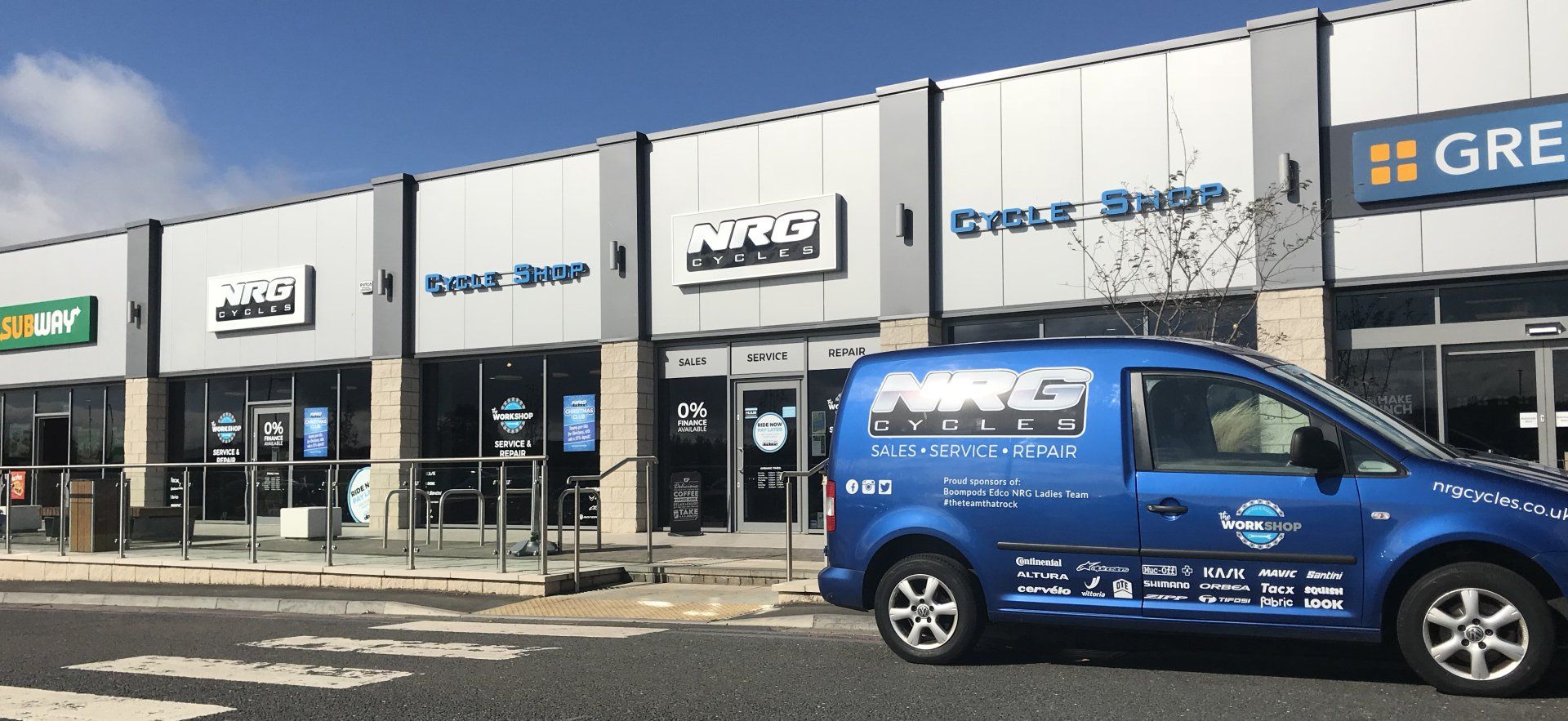 A blue van is parked in front of a building.