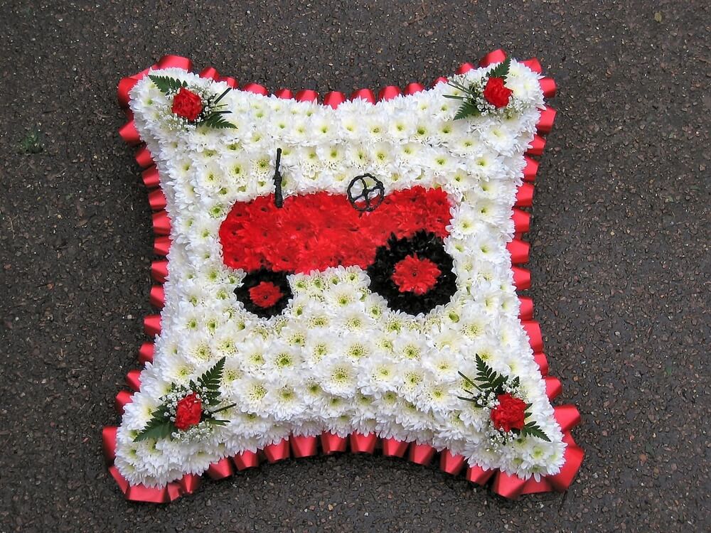 7.  18” white Cushion with custom made old Tractor to the centre, red ribbon edge and red posies to each corner