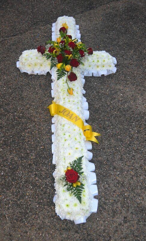 7.  5ft Cross with white ribbon edge, red and yellow Rose posies and ribbon sash