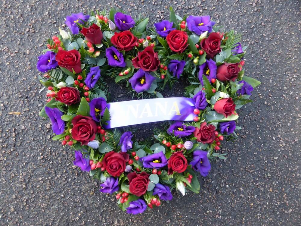 12. Hollow Heart with red Roses and Berries, purple Lisianthus and ribbon sash