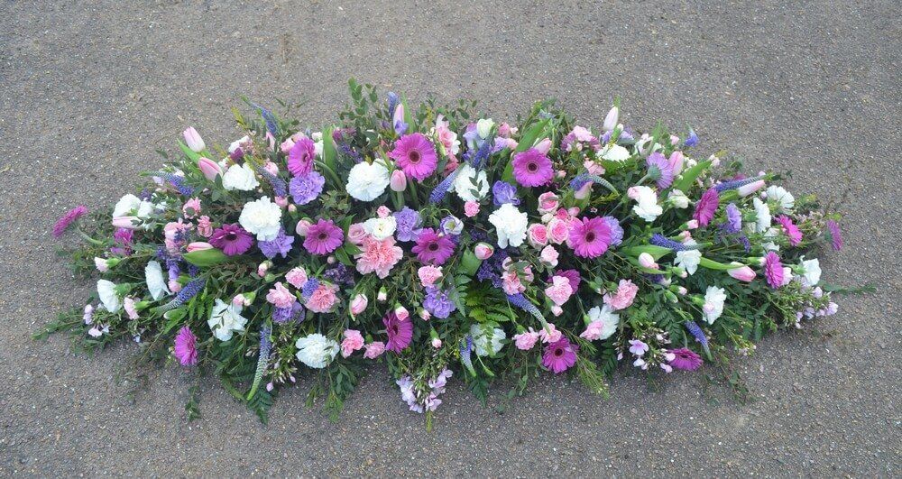 49. Full coffin spray with pink and lilac Carnations, purple Germini and Veronicas, spray Roses, pink Tulips and Phlox