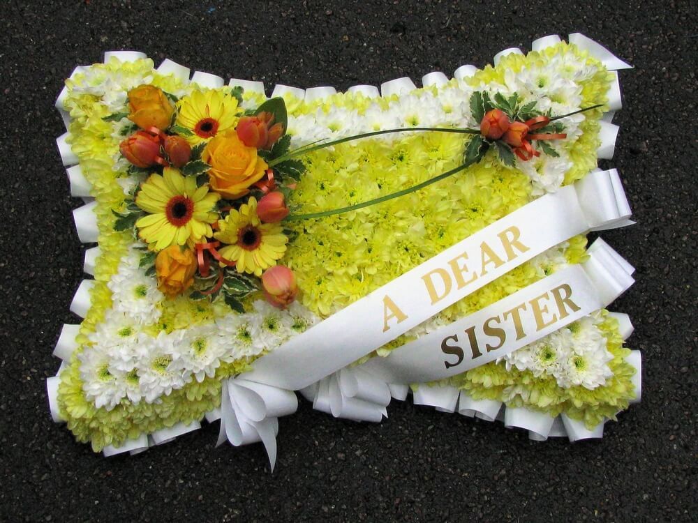 9.  18” yellow and white pillow with white ribbon edge and sash’s, posies of yellow and orange flowers