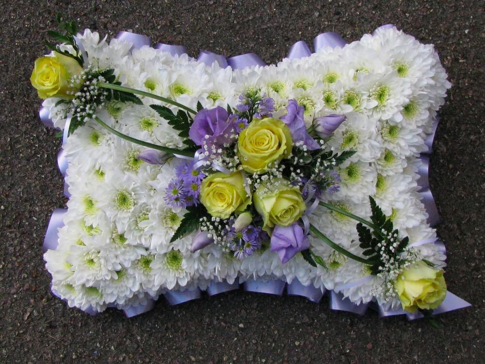 7. 15” White pillow with lilac ribbon edge, lemon Roses and lilac Lisianthus posies