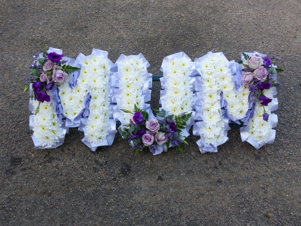 27. White letters with lilac ribbon edge, lilac Roses and purple Lisianthus posies