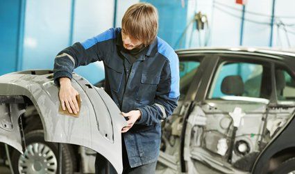 expert mechanic repairing the dents