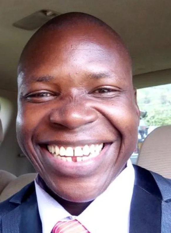 Smiling Black man in a suit and tie, close-up portrait.