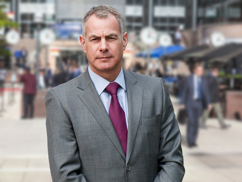 Peter Bassage in a suit and tie is standing in Central London financial district