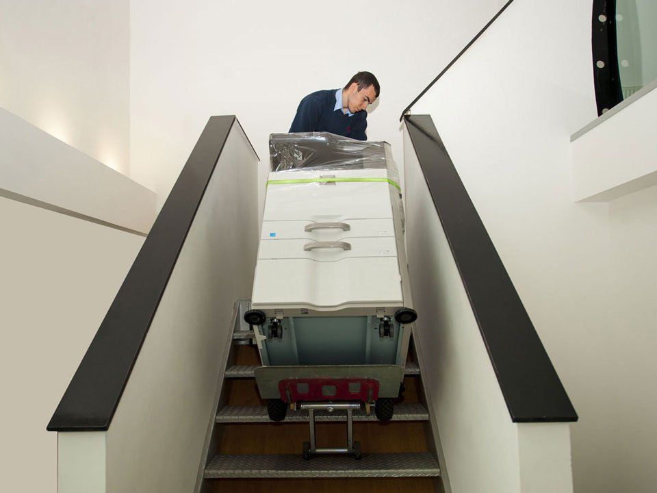 A man is pulling a cart up a set of stairs