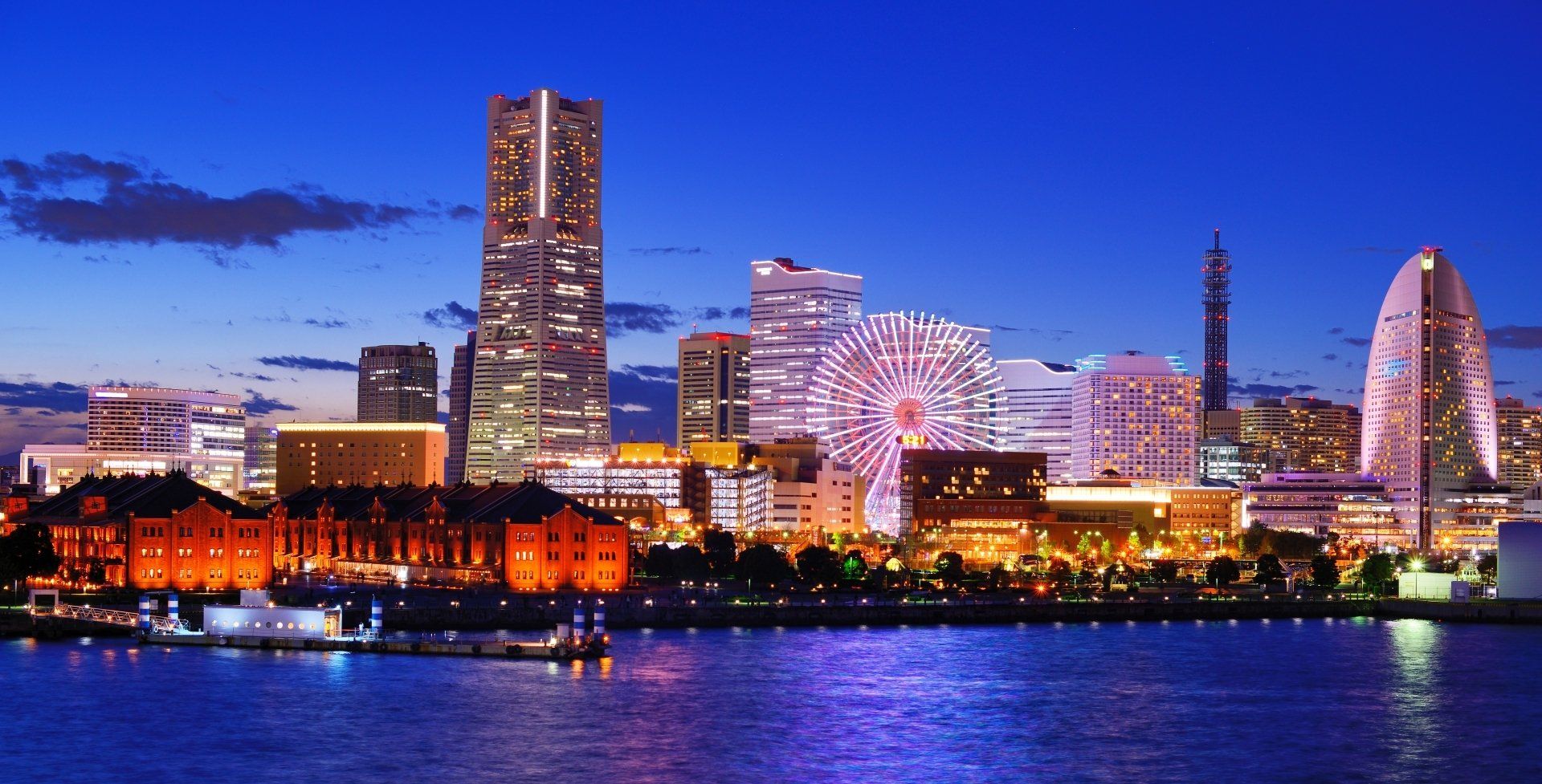 Osaka city skyline at night with a ferris wheel in the foreground