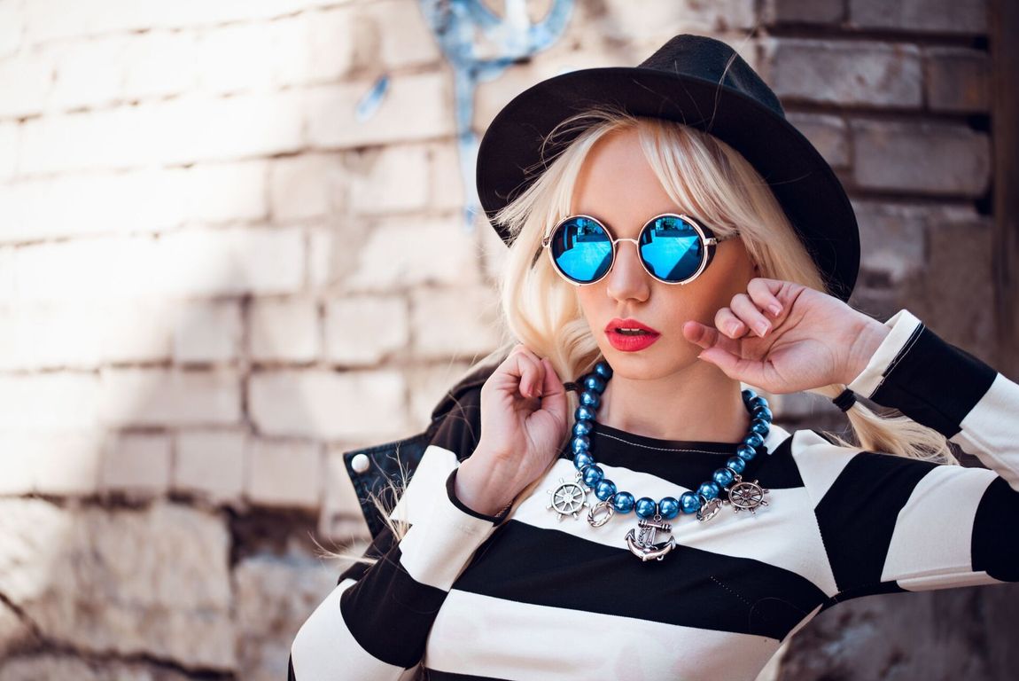 ragazza con occhiali da sole tondi a specchio
