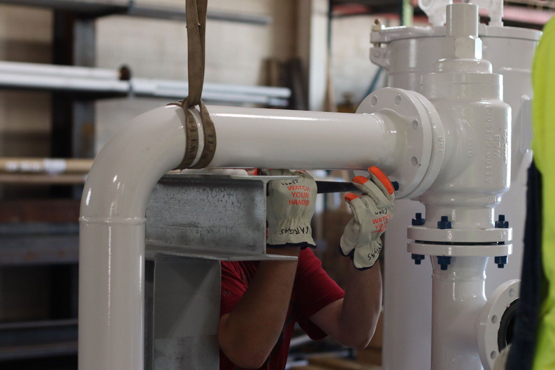 a man is working on a pipe in a factory.