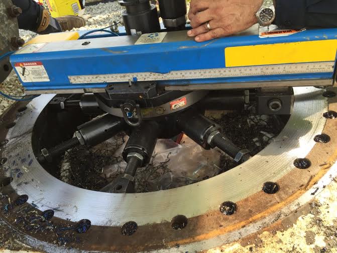 a man is using a machine to drill a hole in a piece of metal 