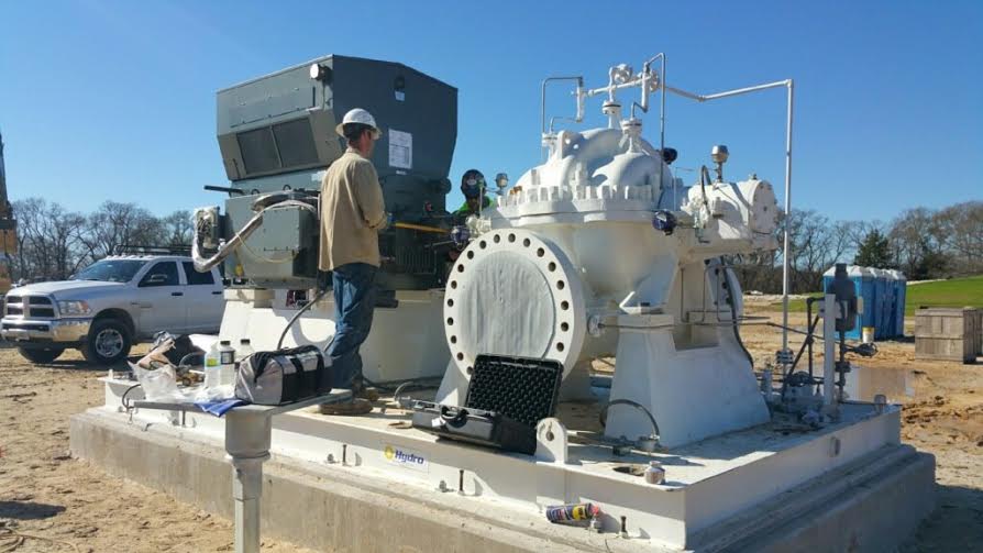 a man is working on a large white machine on a construction site .