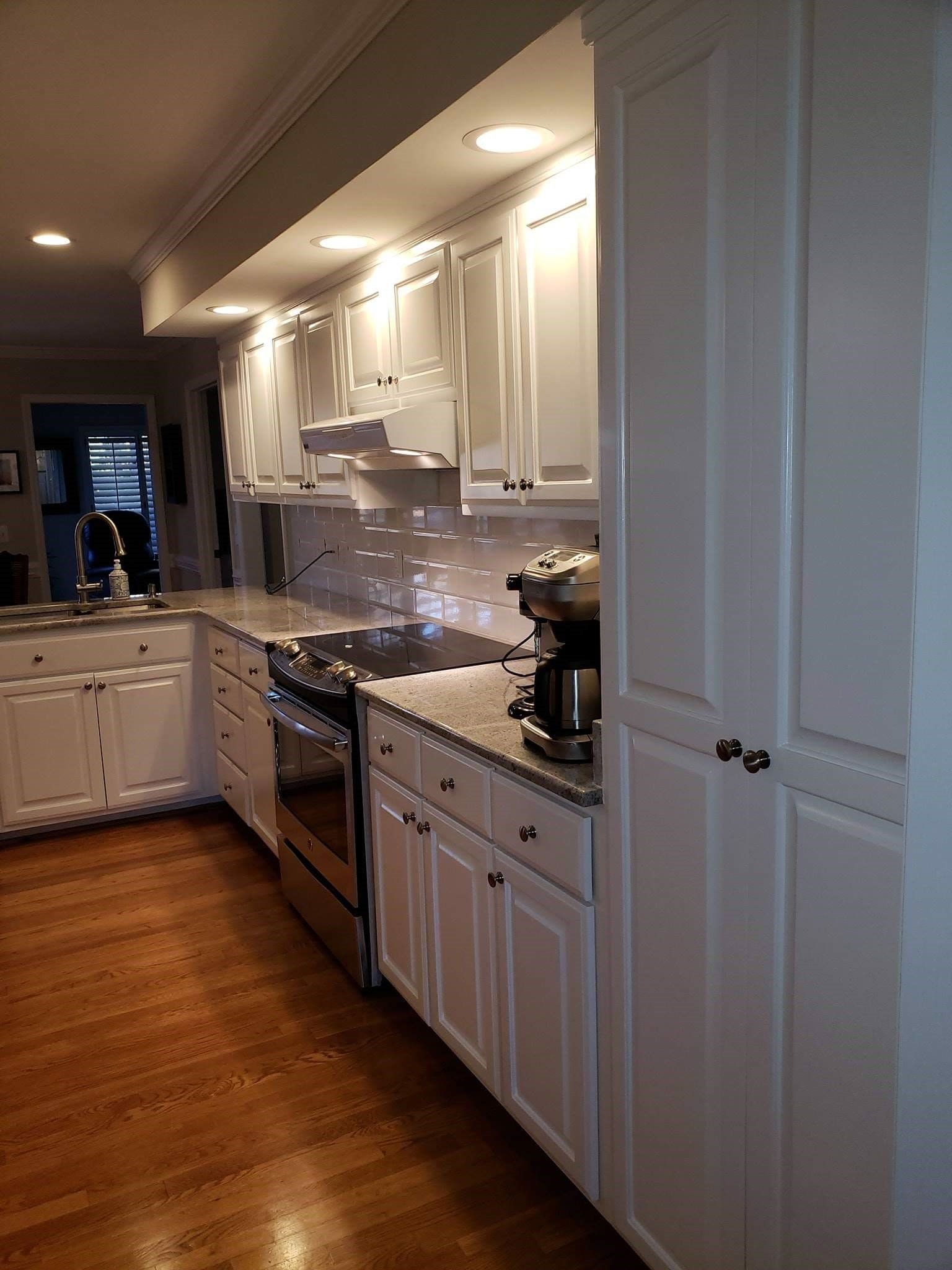 a kitchen with white cabinets and stainless steel appliances .