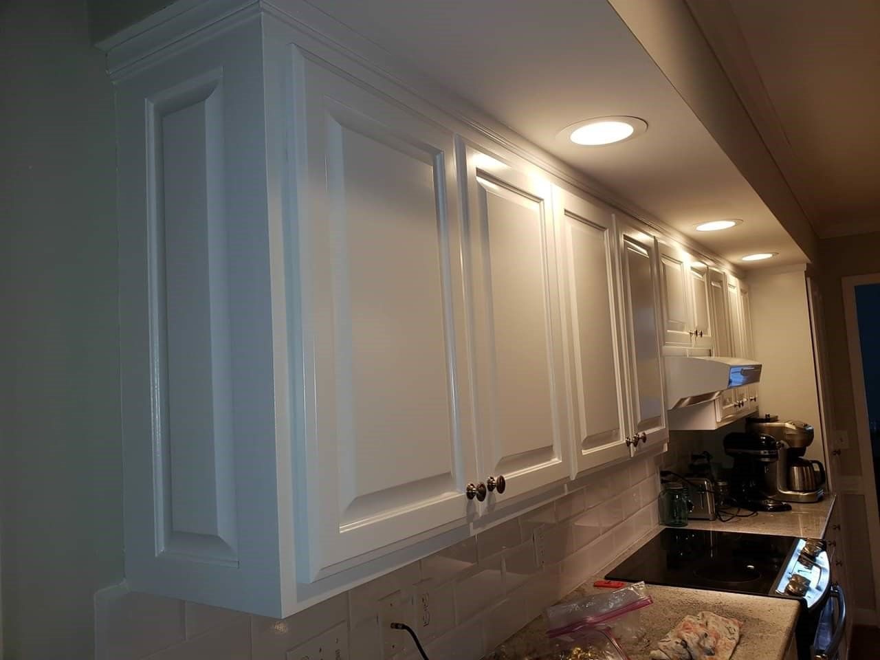 a kitchen with white cabinets and a stove top oven