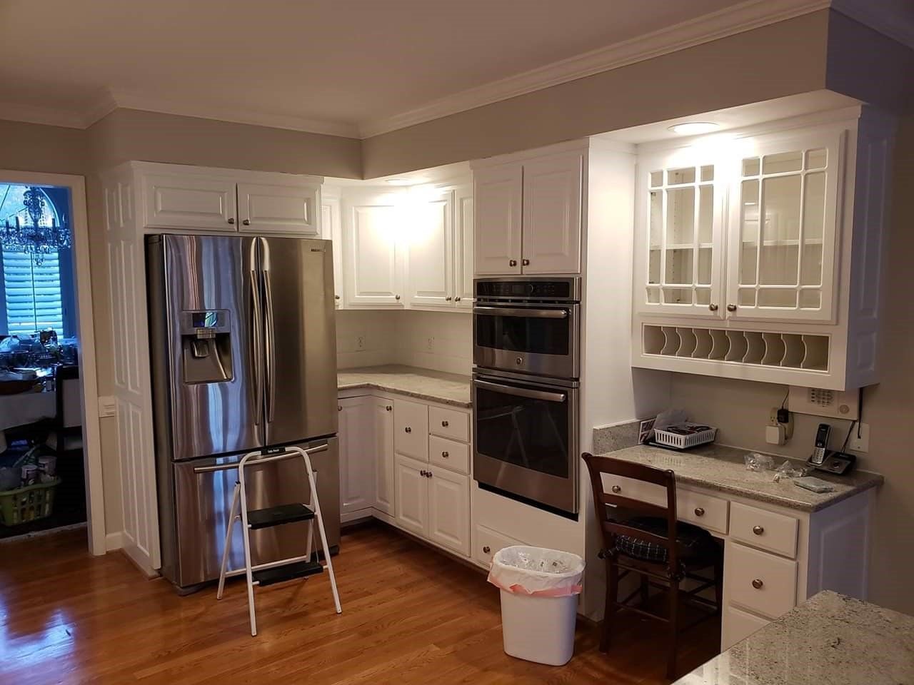 a kitchen with white cabinets and stainless steel appliances .