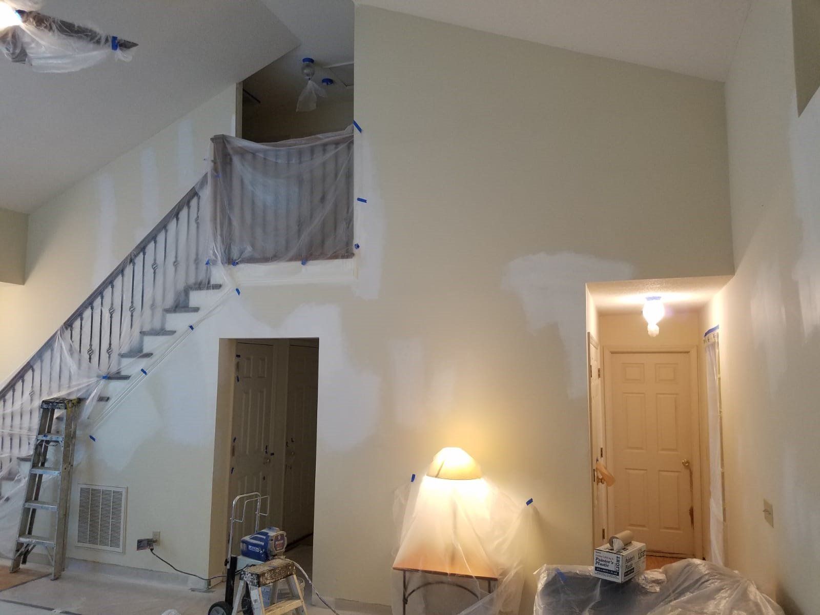 a living room with stairs and a ceiling fan