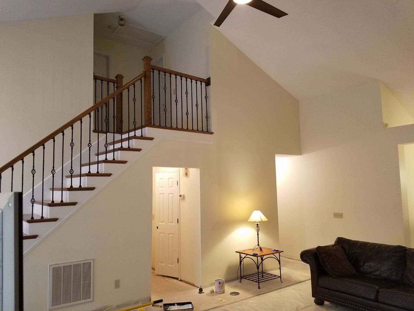 a living room with stairs and a ceiling fan