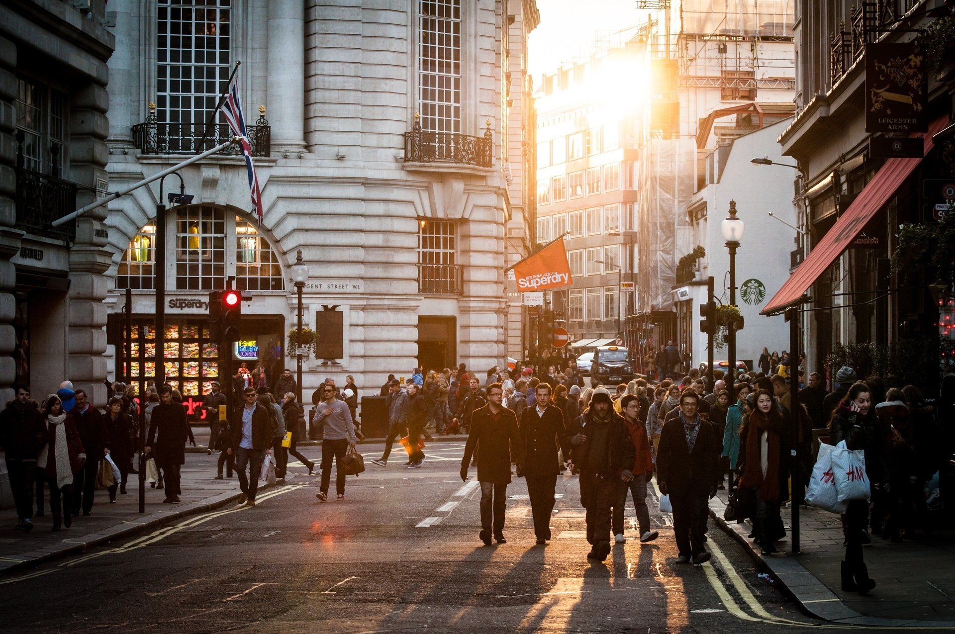 A crowd of people are walking down a city street.