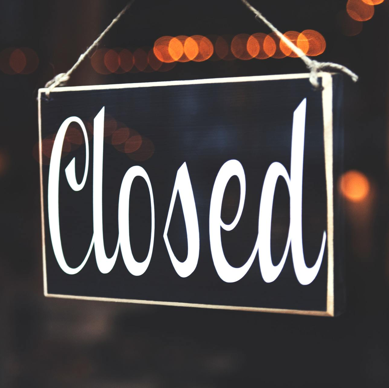 A closed sign hangs in a dark window