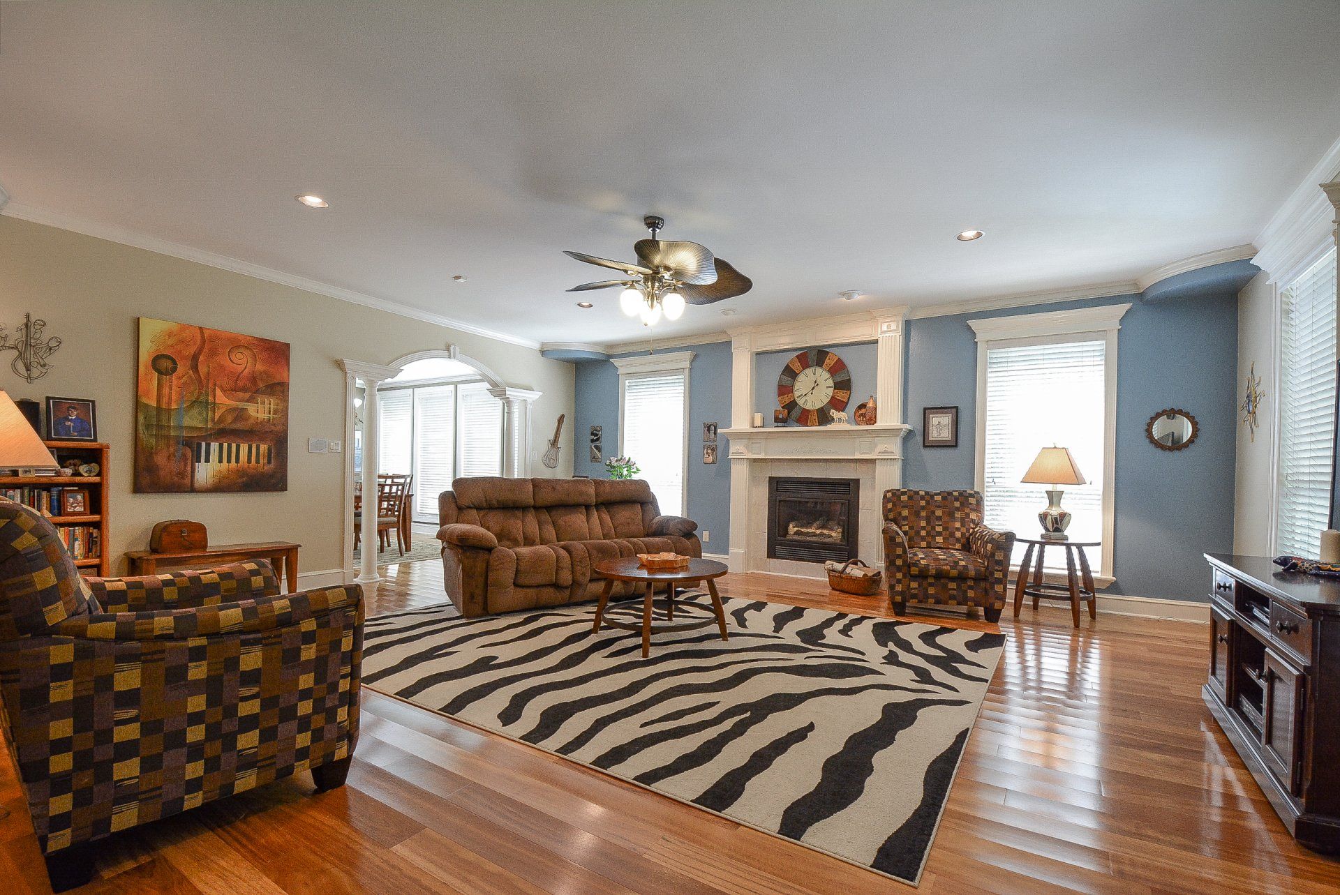Living room with brown furniture, zebra rug, fireplace, and blue walls.