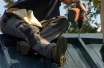 worker constructing sheet metal roof