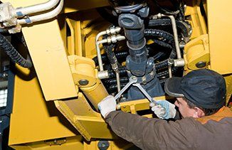 Man Fixing Excavator — Lab Equipment & Supplies in Moorpark, CA Man Fixing Excavator — Lab Equipment & Supplies in Moorpark, CA