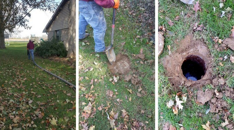 A man is digging a hole in the ground in front of a house.