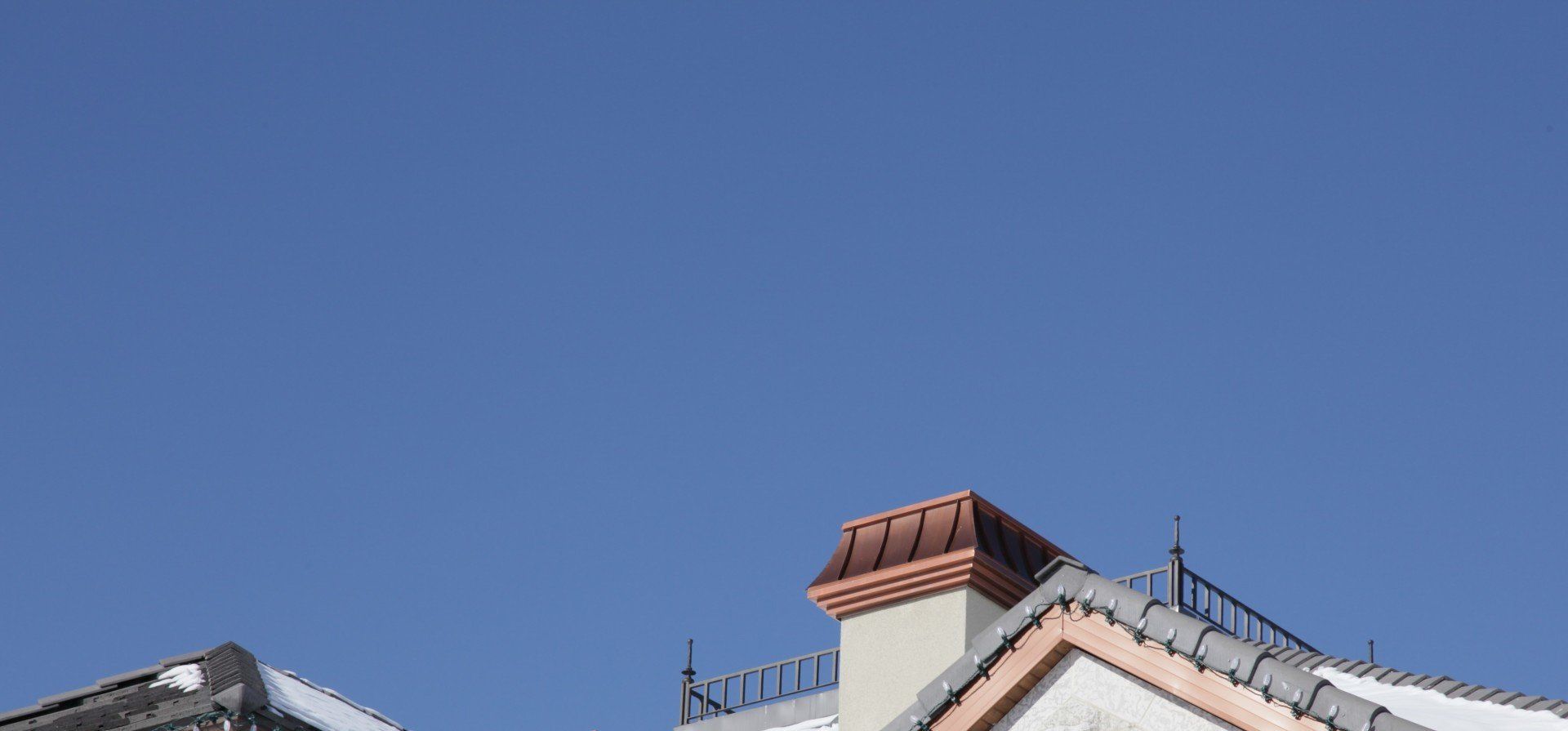 a chimney on the roof of a building with a blue sky in the background