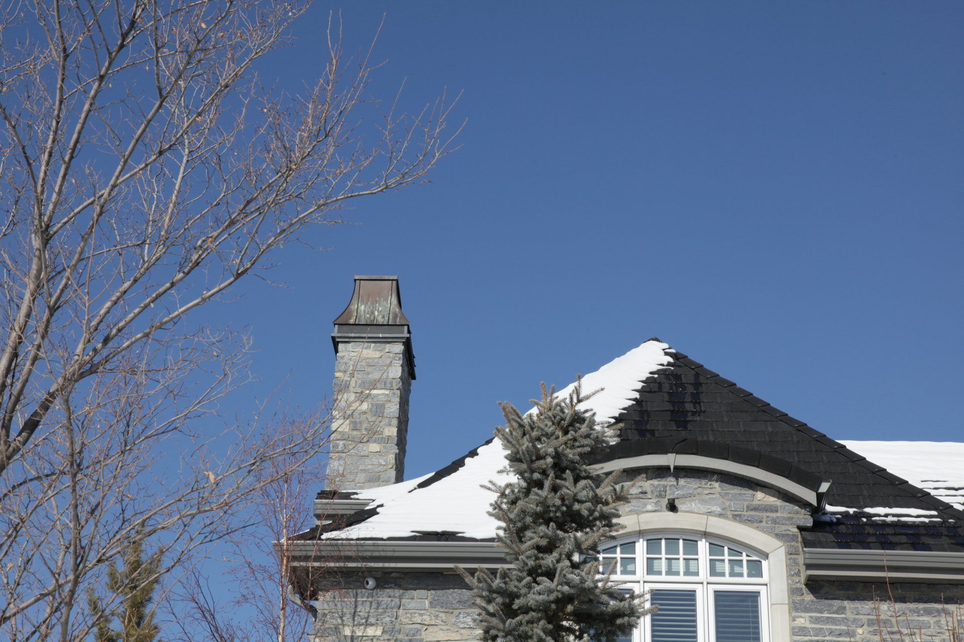 a house with snow on the roof and a chimney