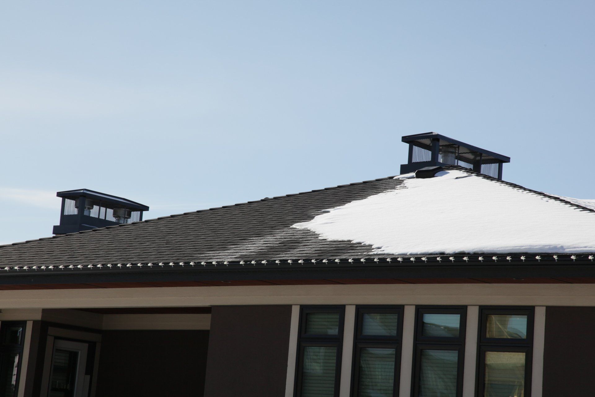 a house with snow on the roof and chimneys
