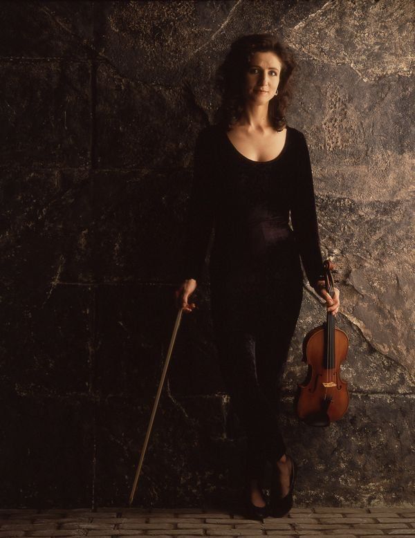 madeleine holding a violin with stone background
