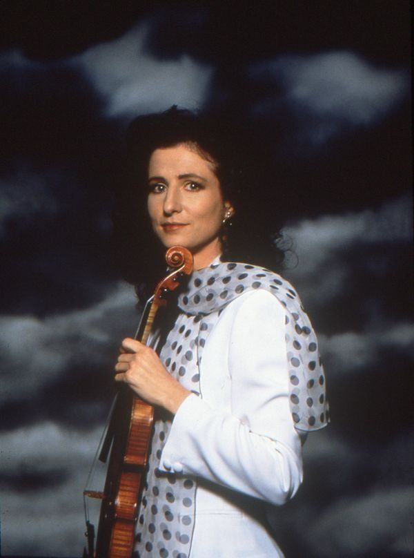 madeleine mitchell holding a violin on clouds background