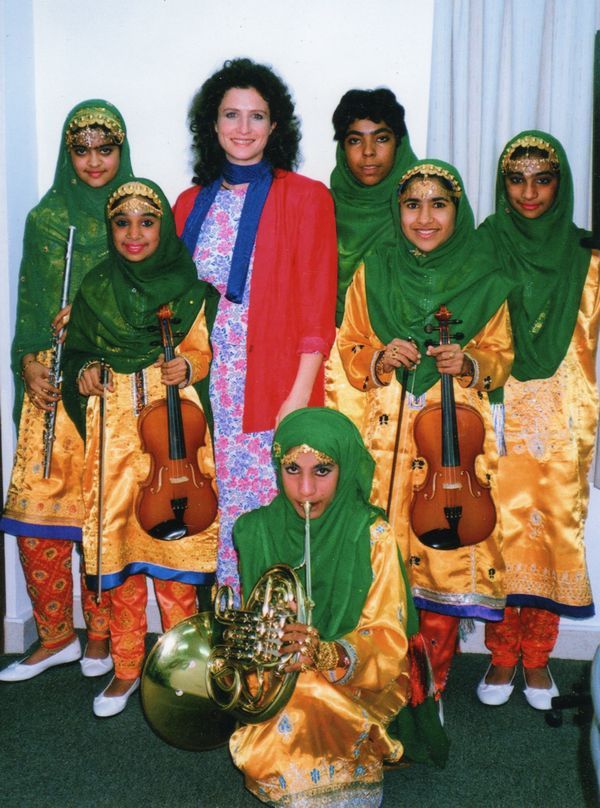 madeleine mitchell surrounded by children with green scarves