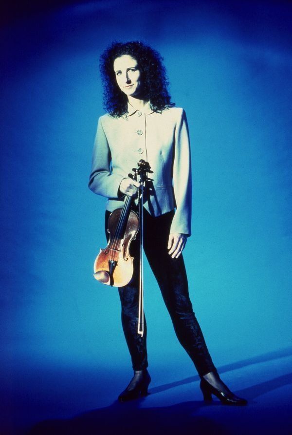 madeleine mitchell holding a violin on electric blue background